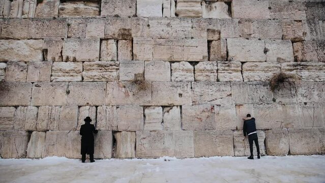 Some people are praying at the Western Wall in winter. January 27th, 2022, old city of Jerusalem, Israel.