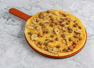 Delicious hot Beef with Mushrooms pizza with melted cheese on wooden round board on marble background