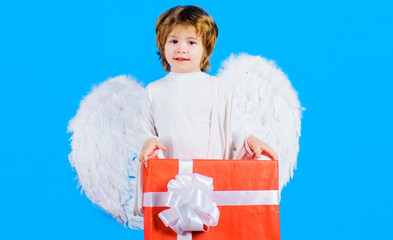 Valentines day. Little angel with gift. Cupid boy with white wings holds present box. February 14.