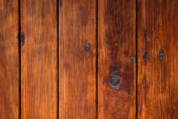 Fototapeta premium Brown wood background. Vertical planks of brown color close-up. Wood texture. Wooden brown boards background. Old fence boards at home. Rough board surface.