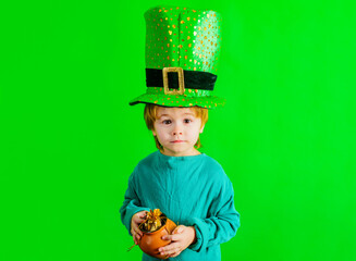 Patrick's Day. Child boy in leprechaun hat holds pot with gold. Irish culture. Traditional holidays.