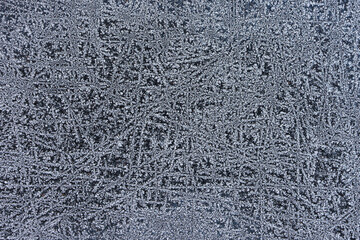 Frozen pattern of hoarfrost and frostwork structure on the glass. Color texture photo for background, wallpaper.
