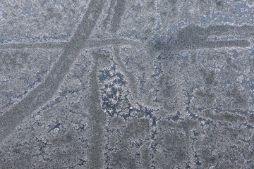 Frozen pattern of hoarfrost and frostwork structure on the glass. Color photo for backgrounds.