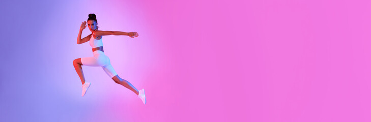 Female Jumping During Fitness Workout Over Pink And Blue Background
