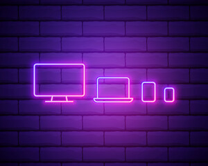Glowing neon Computer monitor, graphic tablet and mobile phone icon isolated on dark background. Earnings in the Internet, marketing. Vector icon set isolated on brick wall