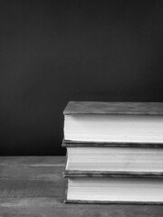 black and white stack of books on a table with copy space