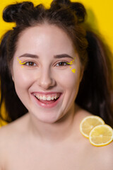 brunette woman girl with lemon near skin face on yellow background. tasty juicy fruit. Tropical fruits, Healthy food. citrus slice.