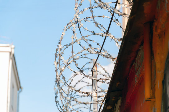 Barbed wire fence against the blue sky. Prison, camp