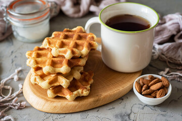 Keto diet: thick almond waffles and a mug of tea on a gray background. Close-up