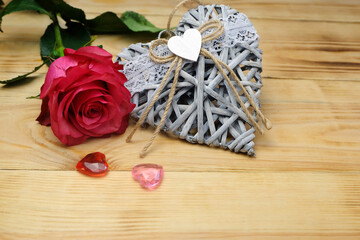 Valentine's day horizontal composition with wicker heart, glass hearts and rose, can be used for greeting cards, posters, placards, covers, etc.