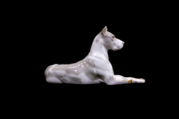 Obraz na płótnie Canvas a dog of the White Great Dane breed is isolated on a black background. porcelain figurine