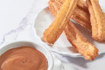 Mexican churros served on a homemade plate.