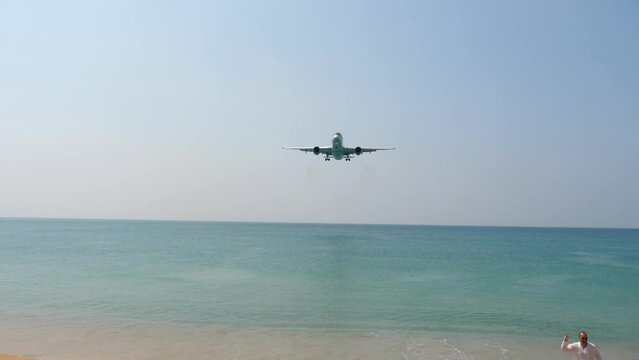 Passenger plane descending to land at Phuket airport. Jet airplane approach over ocean