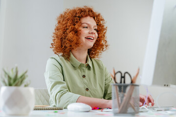 Young business woman with red curly hair working in the office - Powered by Adobe