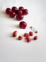 Naklejka na ściany i meble taking heart out of red cherries with a pin 