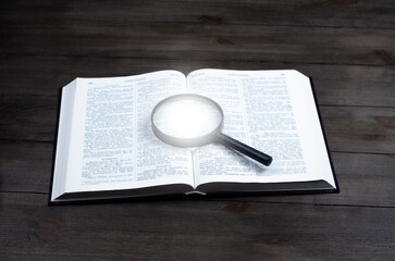 Open Bible. On the table. Holy Bible, Scripture. Magnifier