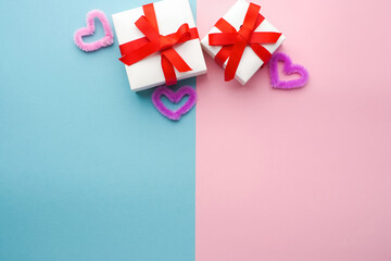 White boxes with gifts on a blue and pink background. St. Valentine's Day. Concept of love and spring. Top view, background, copy space 