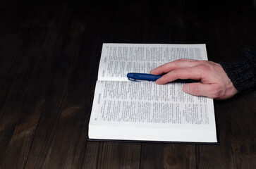 Prayer. Open Bible. Hands folded in prayer. The man is praying. Hands on the table.