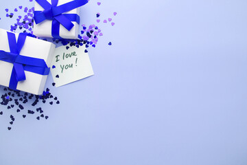 White boxes with gifts on a blue background. St. Valentine's Day. Concept of love and spring. Top view, background, copy space. Lettering: I love you