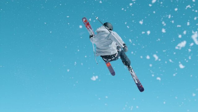 SLOW MOTION: Young male tourist on skiing trip rides around the fun park and does breathtaking tricks. Freestyle skier takes off the kicker and does a difficult 360 grab. Athletic traveler skiing.