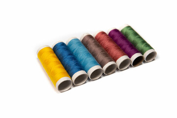 colorful sewing threads on white background for designers