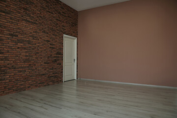 Empty room with different walls, white door and wooden floor