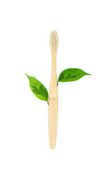 Fototapeta na wymiar eco-friendly bamboo toothbrush in white color and a twig with green leaves lies on a white background. Flat lay, top view. Copy space. Zero waste personal care product, dental care