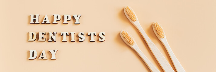 International Dentist Day. Eco-friendly wooden toothbrushes on beige background. Dental care concept.
