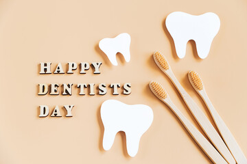 International Dentist Day. Eco-friendly wooden toothbrushes on beige background. Dental care concept.