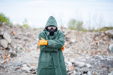 A man in a protective mask and protective clothing explores the danger zone. Ecological...