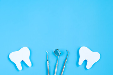 Happy Dentist Day. Paper cut mockup of tooth and dental tool on blue background. Dental care concept.