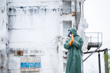 A man in a protective mask and protective clothing explores a dangerous radioactive area.