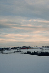 Evening view towards Lensbygda at rural Toten, Norway, in winter.