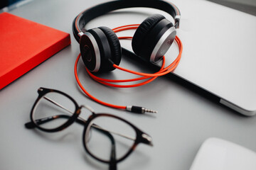 Flat lay workdesk with eyeglasses notebook and red diary on grey background