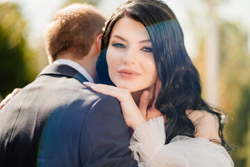 Fototapeta premium the groom gently hugs the bride. happy newlyweds. romantic relationships.