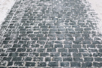 The vintage, grunge gray paving stones. The texture of the old dark stone. Road surface. Winter and...