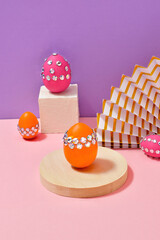 Glamour Easter eggs on pedestals and fan on party background. Creative Easter concept with fashionable design for greeting card or festive sale offer.  Hard shadows, trendy bright colors