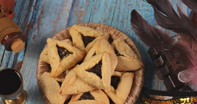 Jewish carnival Purim celebration on hamantaschen cookies, noisemaker and mask with top view from above.
