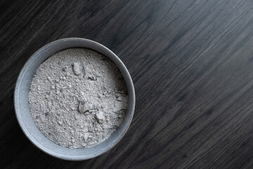 Isolated grey bowl of ashes for ash wednesday on a dark wood background with copy space shot from...