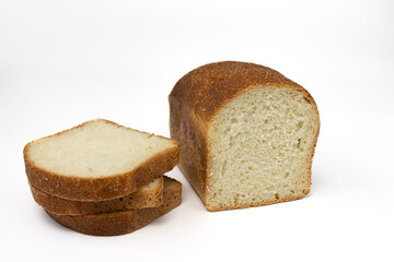 loaf and slices of fresh grain bread on white background