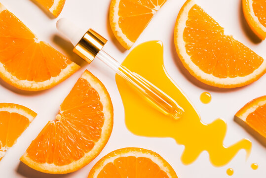 Serum Oil Vitamin C Anti Aging Antioxidant Beauty Care Drops And Dropper On White Background And Slice Of Orange Fruit Natural Organic Cosmetic Concept.