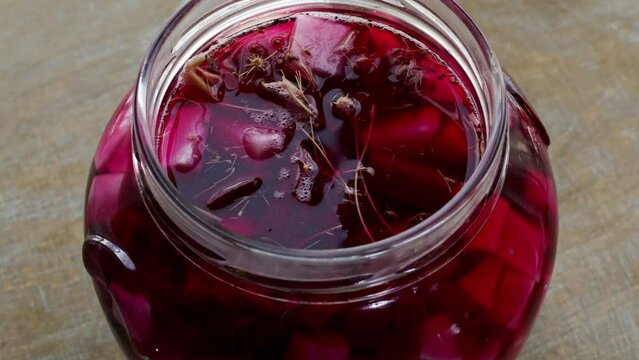 Pickled beetroot with white radish and dill. Glass jar with homemade ferment food vegetable pickle. Open jar, table spin.