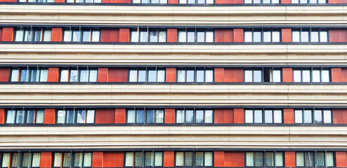 Unusual facade of a high-rise building with red walls. Panorama.