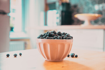 Fototapeta na wymiar bowl of fresh blueberries on rustic kitchen table