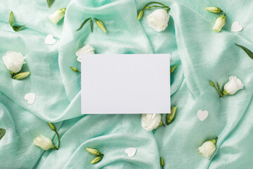 Top view photo of the one card and beautiful white eustomas with flower buds and confetti in shape...