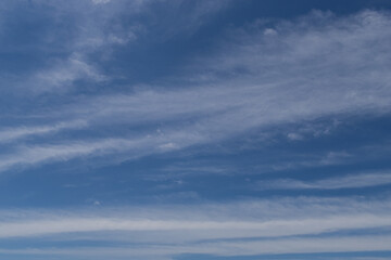 Naklejka na ściany i meble Streaky thin white clouds on blue sky.