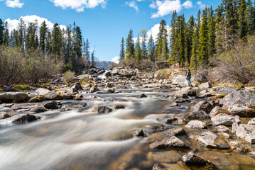 Woman, tourist standing near a waterfall in Canada during summer time. 