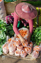 Woman at market selling vegetables.