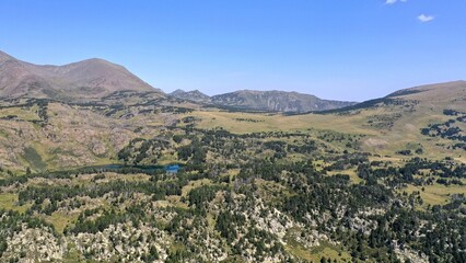 Fototapeta na wymiar survol d'un lac de montagne et des forets dans les Pyrénées-Orientales, sud de la France, parc naturel des Bouillouses 