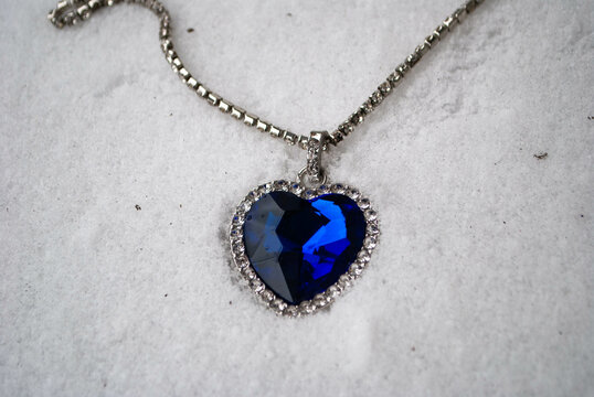 Close-up Of The Heart Of The Ocean Necklace On Snow. Titanic Necklace. Blue Diamond In A Heart Shape. Diamond Necklace.